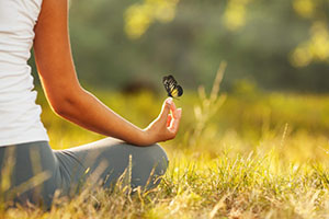 Young woman practicing morning meditation in nature at the park.